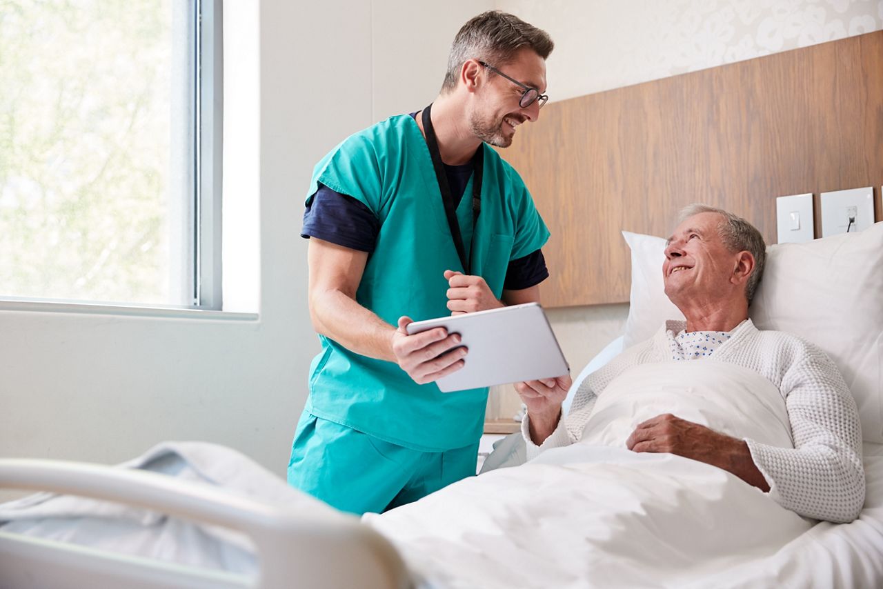 Surgeon With Digital Tablet Visiting Senior Male Patient In Hospital Bed In Geriatric Unit; Shutterstock ID 1393763357; purchase_order: DNC Thumbnails; job: Collections; client: ; other: 