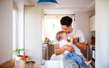 A father bottle feeding a small toddler son indoors at home.; Shutterstock ID 1426502138; purchase_order: DNC Thumbnails; job: Webinars 2 (50/188); client: ; other: 