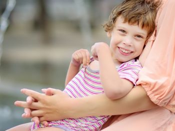 Close-up portrait of beautiful disabled girl in the arms of his mother having fun in fountain of public park at sunny summer day. Child cerebral palsy. Inclusion.; Shutterstock ID 1431395513; purchase_order: DNC Thumbnails; job: Webinars 3 (50/188); client: ; other: 