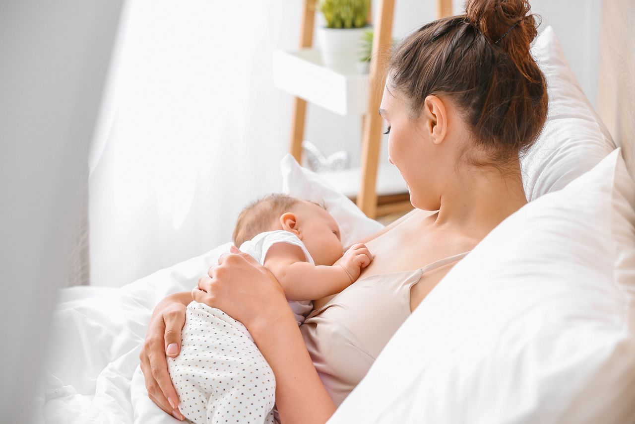 Young woman breastfeeding her baby at home; Shutterstock ID 1452282566; purchase_order: DNC Thumbnails; job: Collections; client: ; other: 