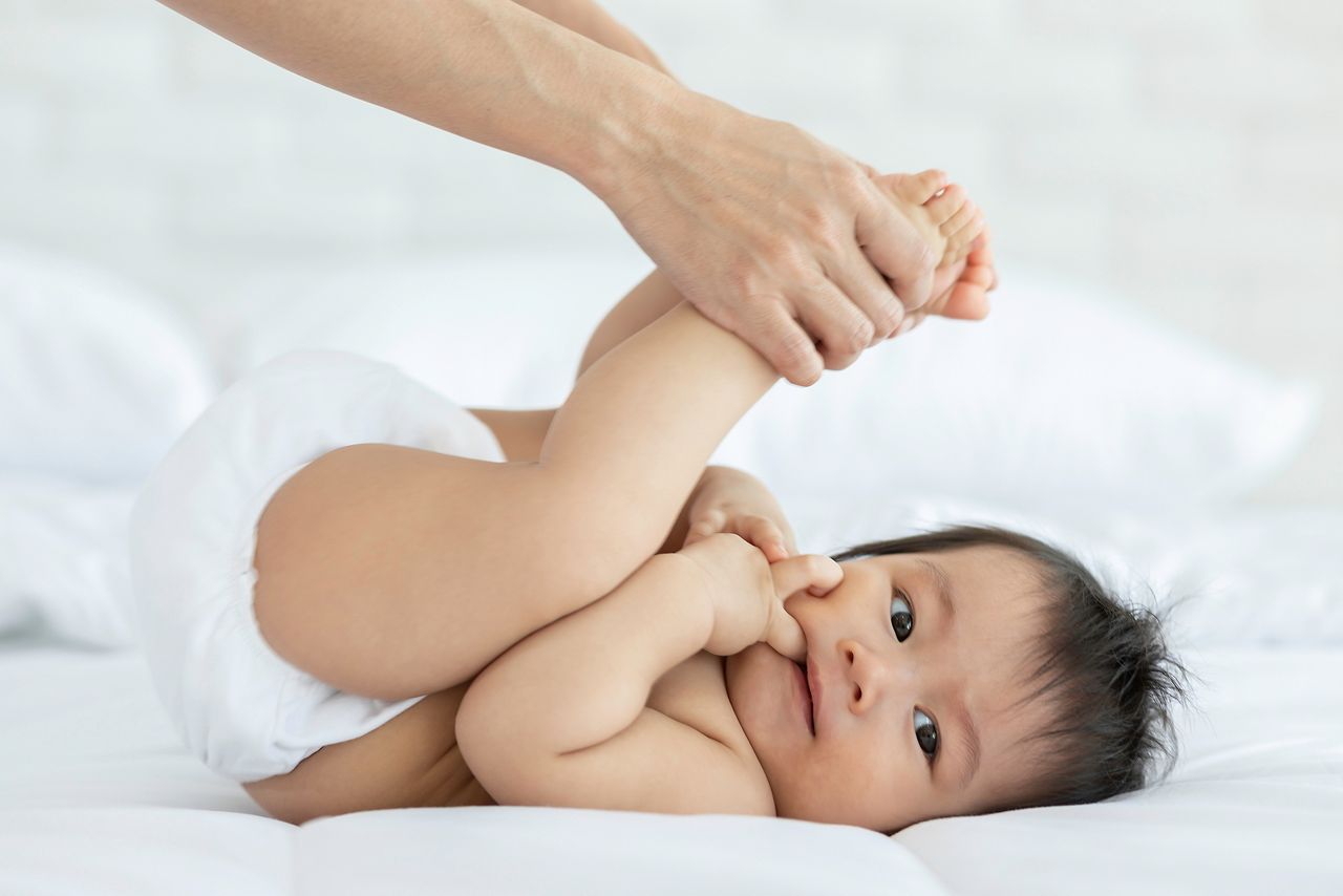 Close up mother Hands Holding Baby leg and Exercise for Healthy on bed smiling and  happiness emotional in cozy bedroom,Exercise Healthy Baby Concept; Shutterstock ID 1453447595; purchase_order: SN event thumbnails; job: ; client: ; other: 