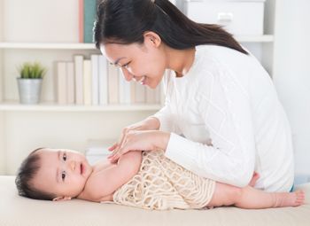 Asian mother giving massage to baby girl at home.; Shutterstock ID 156421367; purchase_order: DNC thumbnail; job: ; client: ; other: 