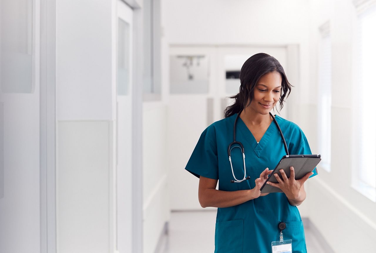 Female Doctor Wearing Scrubs In Hospital Corridor Using Digital Tablet; Shutterstock ID 1637163520; purchase_order: DNC Thumbnails; job: Webinars 4 ; client: ; other: 