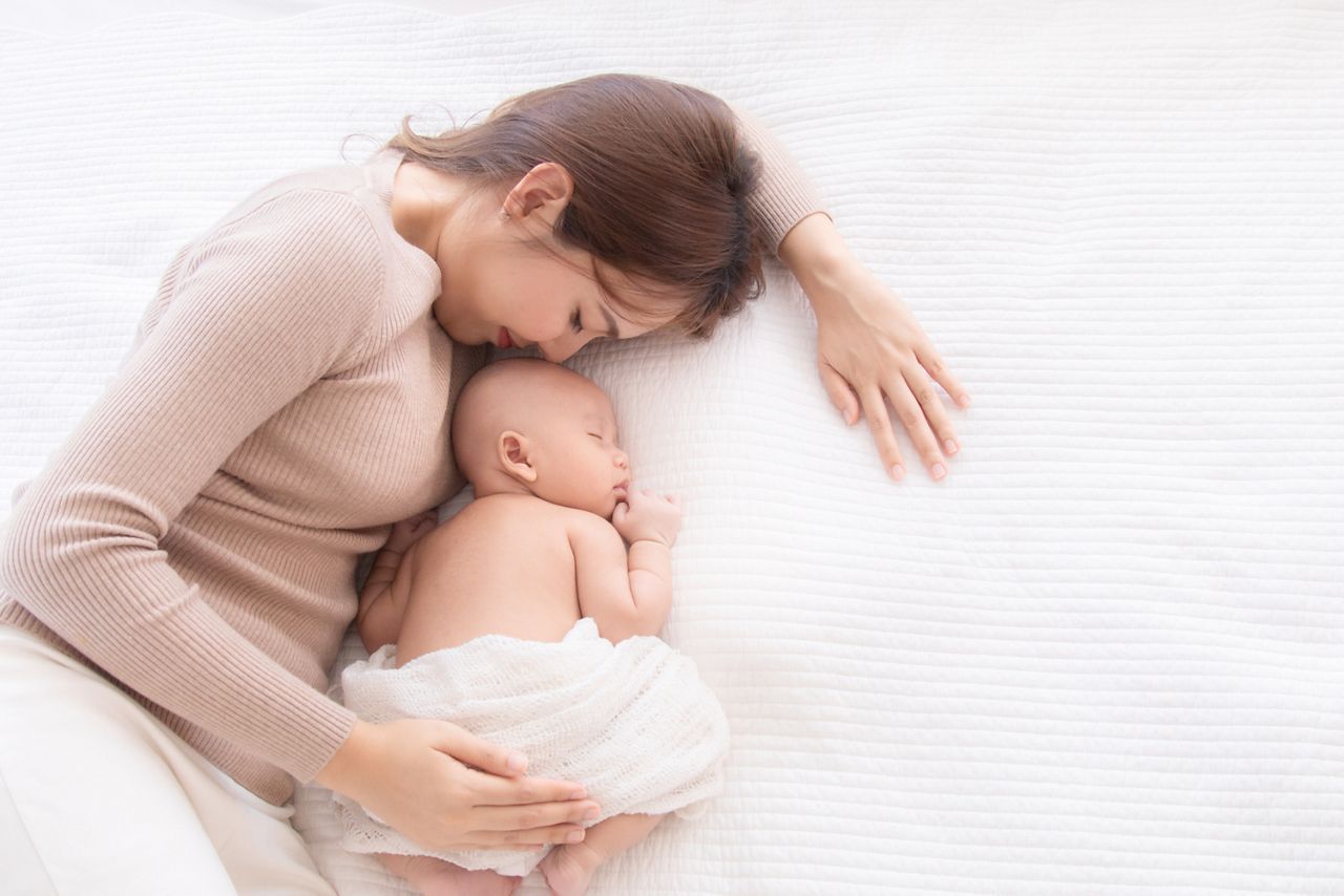 Asian beautiful mom motherhood lie down nursing, kissing newborn baby infant toddler, gently hold together on chest with love, infant sleep comfortable with safe and protection by mother taking care; Shutterstock ID 1675808368; purchase_order: SN event thumbnails; job: ; client: ; other: 
