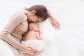 Asian beautiful mom motherhood lie down nursing, kissing newborn baby infant toddler, gently hold together on chest with love, infant sleep comfortable with safe and protection by mother taking care; Shutterstock ID 1675808368; purchase_order: SN event thumbnails; job: ; client: ; other: 