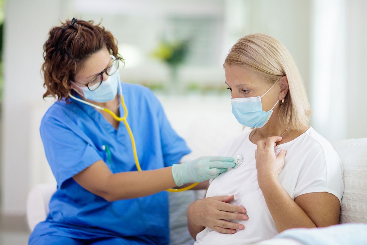 Doctor examining sick patient in face mask. Ill woman in health clinic for test and screening. Home treatment of virus. Coronavirus pandemic. Covid-19 outbreak. Woman coughing, having chest pain.; Shutterstock ID 1718116291; purchase_order: DNC Thumbnails; job: Webinars 3 (50/188); client: ; other: 