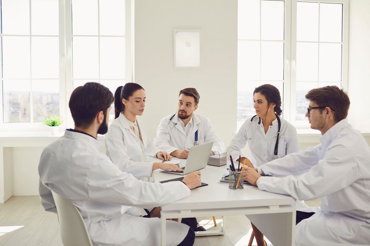 Group of doctors talking sitting at a table in the office of the hospital; Shutterstock ID 1733037653; purchase_order: DNC Thumbnails; job: Webinars 2 (50/188); client: ; other: 
