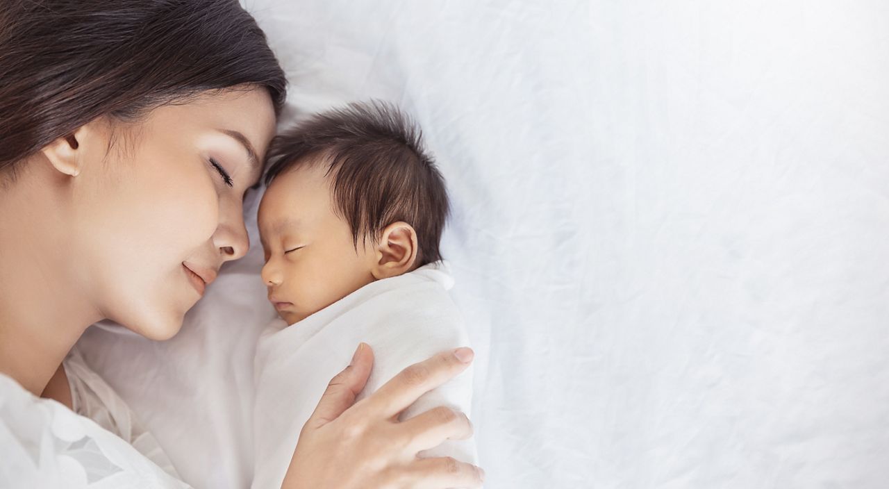 Close up portrait of beautiful young asian caucasian mother day girl kissing healthy newborn baby sleep in bed with copy space. Healthcare and medical love asia woman lifestyle mother's day concept; Shutterstock ID 1736337146; purchase_order: DNC Thumbnails; job: Collections; client: ; other: 
