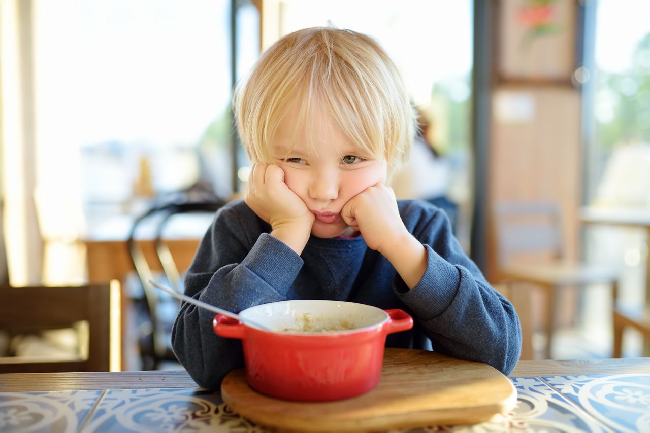 Little child sitting the table in cafe or restaurant and doesn't want to eat. Healthy food. Kids diet. Poor appetite. Grandmother upbringing.; Shutterstock ID 1756007969; purchase_order: DNC Thumbnails; job: Articles; client: ; other: 