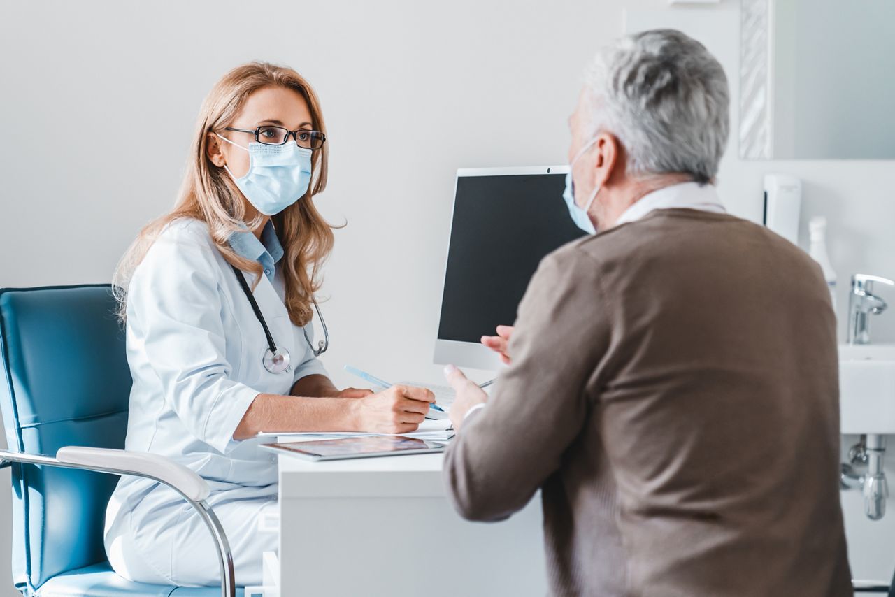 Woman doctor wear protection face mask talking with patient in clinic office; Shutterstock ID 1793456923; purchase_order: DNC Thumbnails; job: Publications; client: ; other: Replace Fishwife