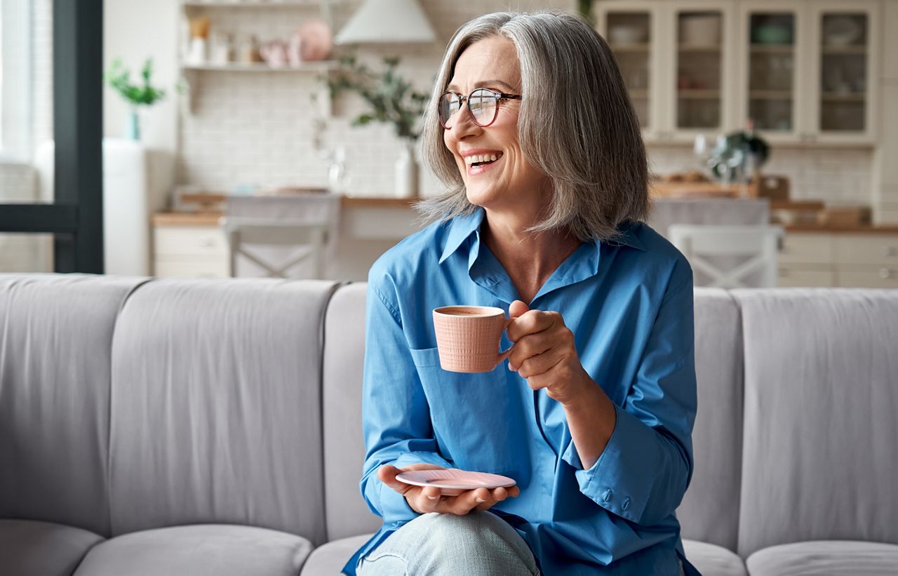 Happy beautiful relaxed mature older adult grey-haired woman drinking coffee relaxing on sofa at home. Smiling stylish middle aged 60s lady enjoying resting sitting on couch in modern living room.; Shutterstock ID 1818491870; purchase_order: DNC Thumbnails; job: Webinars 4 ; client: ; other: 