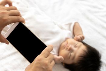 A woman's hand shooting a baby with a smartphone; Shutterstock ID 1818502973; purchase_order: DNC thumbnails; job: FG Infograhpics; client: ; other: 