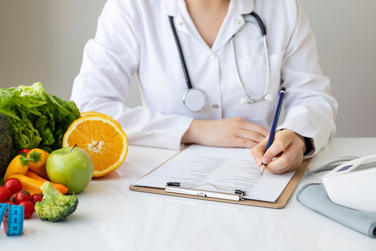 Female nutritionist doctor writing vegetable diet plan; Shutterstock ID 1915531801; purchase_order: 25 thumbnail photos ; job: ; client: ; other: 