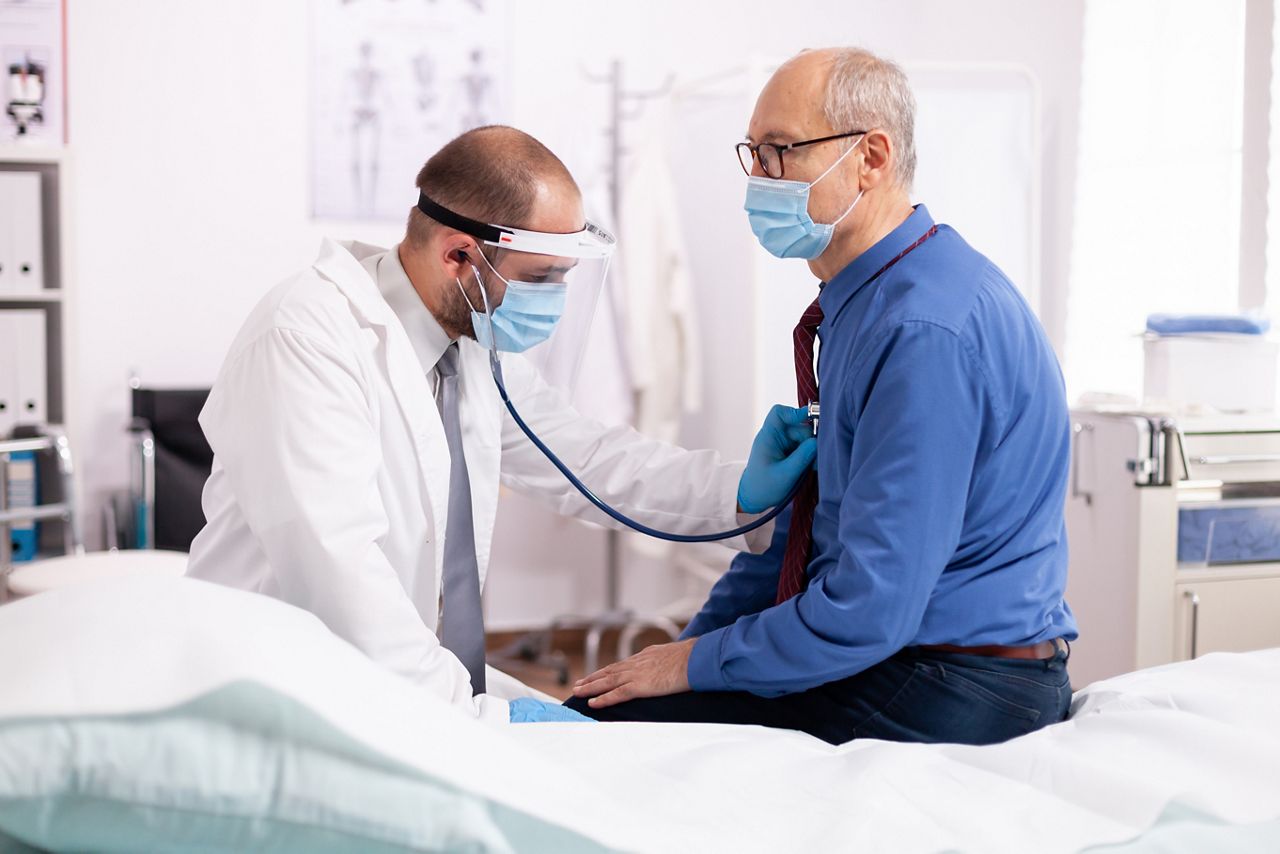 Doctor examining patient lungs using stethoscope wearing face mask as safety precaution in time of covid19. Medical practitioner wearing face mask consulting senior man in examination room during; Shutterstock ID 1917257714; purchase_order: DNC Thumbnails; job: Webinars 1 (50/189); client: ; other: 