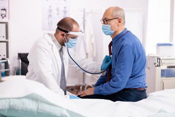 Doctor examining patient lungs using stethoscope wearing face mask as safety precaution in time of covid19. Medical practitioner wearing face mask consulting senior man in examination room during; Shutterstock ID 1917257714; purchase_order: DNC Thumbnails; job: Webinars 1 (50/189); client: ; other: 