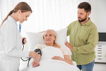Mature woman with doctor and son in hospital room; Shutterstock ID 1917912362; purchase_order: SN event thumbnails; job: ; client: ; other: 
