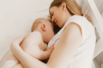 Beautiful young mom and her cute little baby sleeping in bed at home; Shutterstock ID 1919439980; purchase_order: DNC Thumbnails; job: Publications; client: ; other: 