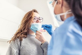 Smiling girl puts face mask off her nose so that a healthcare worker can take a sample for Covid-19 testing.; Shutterstock ID 1934424008; purchase_order: DNC Thumbnails; job: Infographics; client: ; other: 