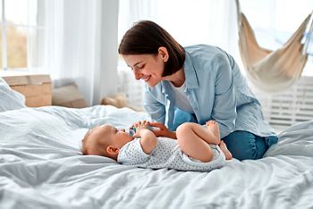 Cute baby drinking milk from baby bottle while looking his mom. Mother feeding son infant from bottle. Little boy drinking milk from bottle at home.; Shutterstock ID 1998028190; purchase_order: DNC Thumbnails; job: Webinars 2 (50/188); client: ; other: 