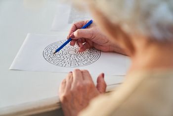 Elderly woman with pen solves a maze puzzle as a brain teaser and memory training against dementia; Shutterstock ID 2007757535; purchase_order: DNC Thumbnails; job: Publications; client: ; other: 