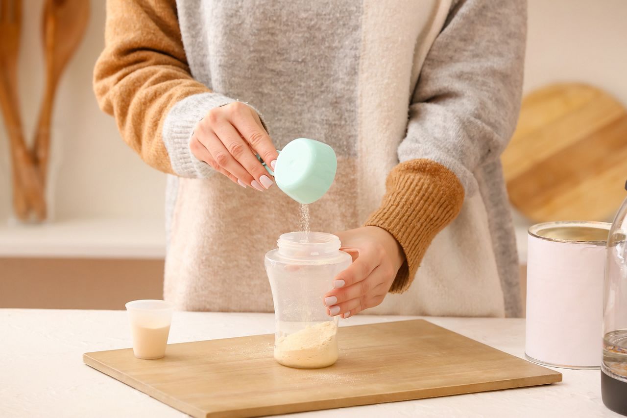 Woman preparing baby milk formula in kitchen; Shutterstock ID 2094738268; purchase_order: DNC Thumbnails; job: Infographics; client: ; other: 