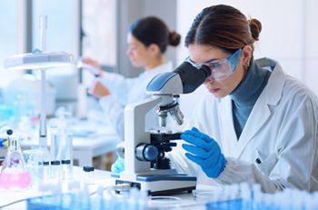 Young scientists conducting research investigations in a medical laboratory, a researcher in the foreground is using a microscope; Shutterstock ID 2149947783; purchase_order: DNC Thumbnails; job: Webinars 3 (50/188); client: ; other: 