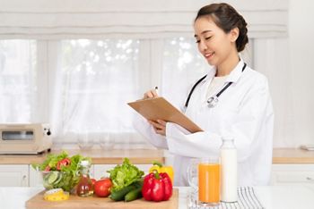 Nutritionist desk with healthy fruit, juice and measuring tape. Dietitian working on diet plan. Weight loss and right nutrition concept; Shutterstock ID 2362052925; purchase_order: 25 thumbnail photos ; job: ; client: ; other: 