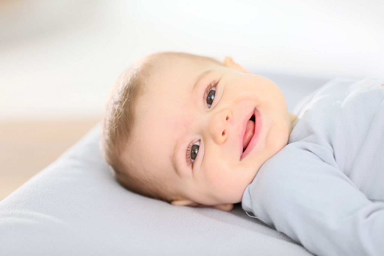 Portrait of smiling baby boy laying on changing table; Shutterstock ID 247171246; purchase_order: DNC Thumbnails; job: Webinars 1 (50/189); client: ; other: 