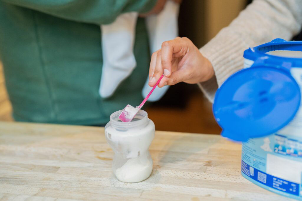 Mother preparing baby formula at home