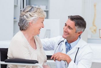 Happy male doctor looking at female patient in clinic; Shutterstock ID 257431399; purchase_order: DNC Thu  ; job: ; client: ; other: 