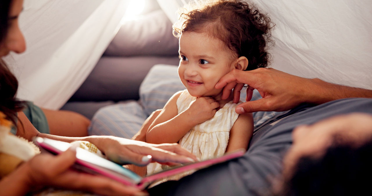 Tent, parents and love with child in home for bonding together, story time and connection with trust. Book, people and fun activity with toddler in blanket fort for happy relationship, smile or care