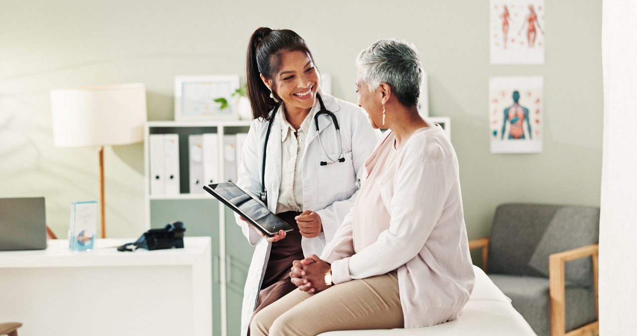 Mature patient, doctor and tablet for healthcare, support or conversation with checkup appointment in office. Female person, medical professional and diagnosis talk for senior woman at clinic
