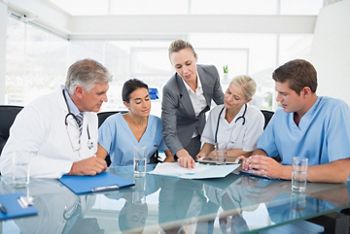 Team of doctors and businesswoman having a meeting in medical office; Shutterstock ID 281577389; purchase_order: DNC Thumbnails; job: Webinars 5 ; client: ; other: Accidentally skipped