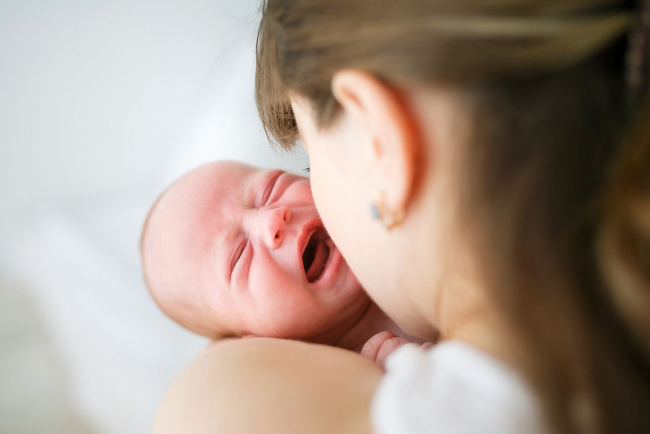 Mother holding her crying little son in studio; Shutterstock ID 301455563; purchase_order: DNC Thumbnails; job: Podcasts (3/6); client: ; other: 