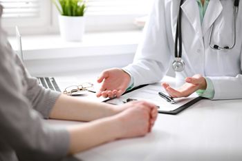 Close up of doctor and  patient  sitting at the desk near the window in hospital; Shutterstock ID 532203136; purchase_order: DNC Thumbnails; job: Videos; client: ; other: Replace Fishwife