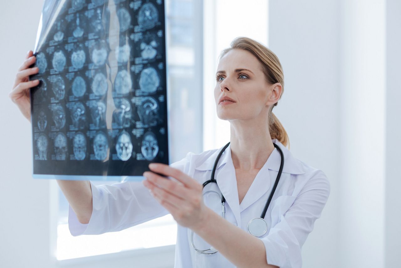 Attentive radiologist examining x ray at the clinic; Shutterstock ID 654692689; purchase_order: DNC Thumbnails; job: Webinars; client: ; other: Replacements