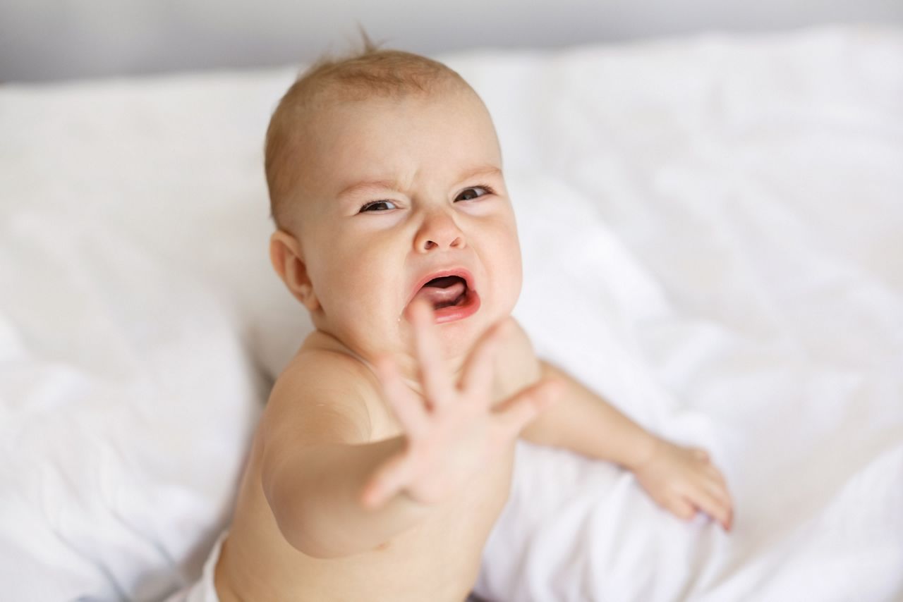 Cute nice little baby girl crying lying with her mom on bed at home.; Shutterstock ID 691237645; purchase_order: DNC Thumbnails; job: Webinars 4 ; client: ; other: 