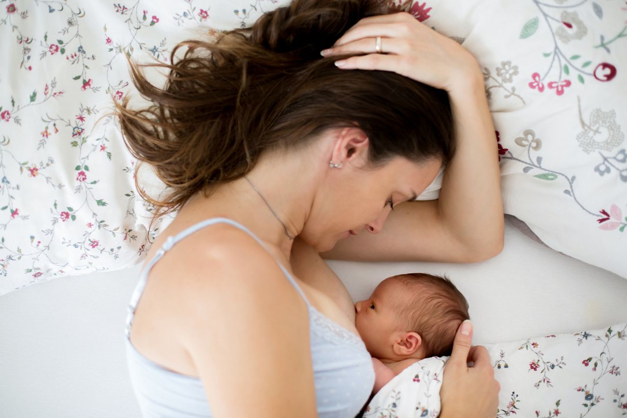 Young mother breastfeeds her baby, holding him in her arms and smiling from happiness; Shutterstock ID 695265856; purchase_order: DNC Thumbnails; job: Webinars 3 (50/188); client: ; other: 