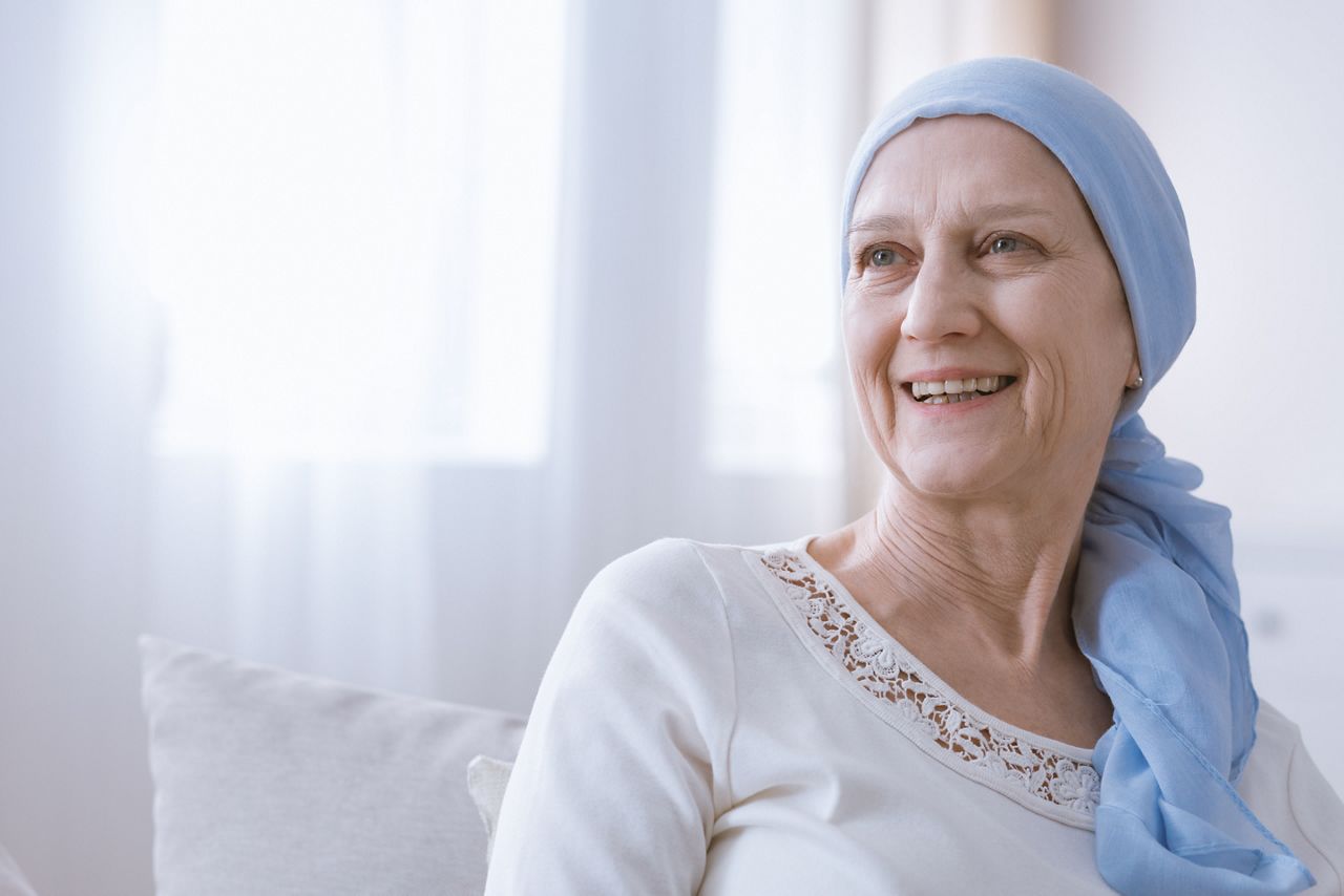 Happy woman with cancer in blue headscarf smiling with hope; Shutterstock ID 706511602; purchase_order: DNC Thumbnails; job: Webinars 1 (50/189); client: ; other: 
