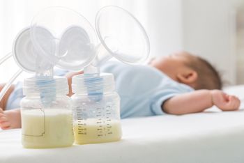 Breast milk pump and baby lying on the white bed; Shutterstock ID 742203778; purchase_order: DNC Thumbnails; job: Infographics; client: ; other: 