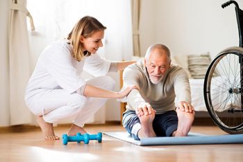 Health visitor and a senior man during home visit. A nurse or a physiotherapist helping a senior man exercise.; Shutterstock ID 754469254; purchase_order: DNC Thumbnails; job: Webinars 3 (50/188); client: ; other: 