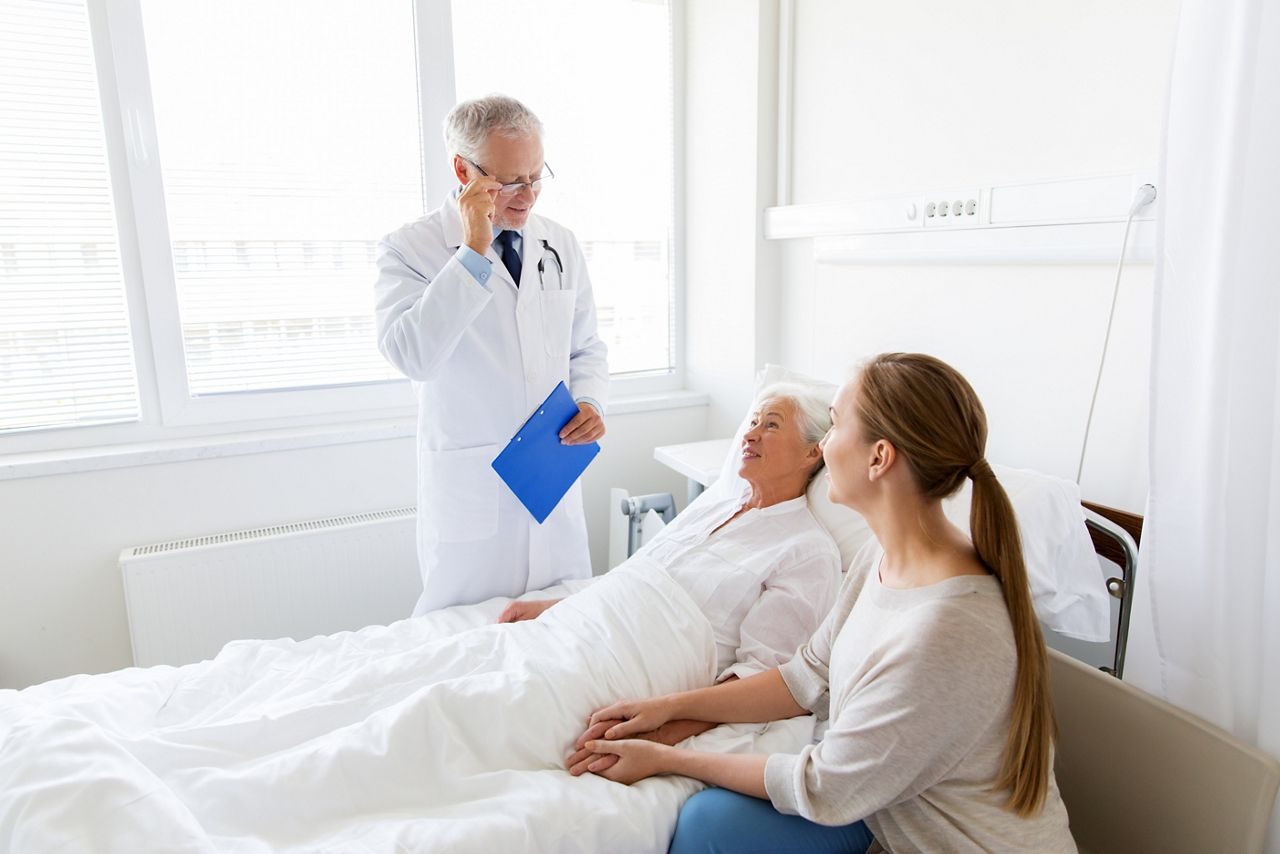 medicine, healthcare and people concept - senior woman patient with daughter and doctor with clipboard at hospital ward; Shutterstock ID 769711498; purchase_order: DNC Thumbnails; job: Webinars; client: ; other: Replacements