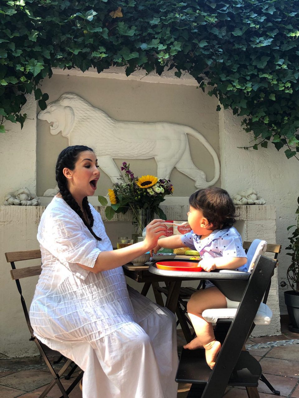 Sila Sahin füttert Kleinkind draußen