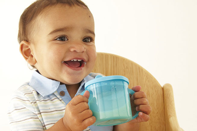 smiling toddler drinking milk
