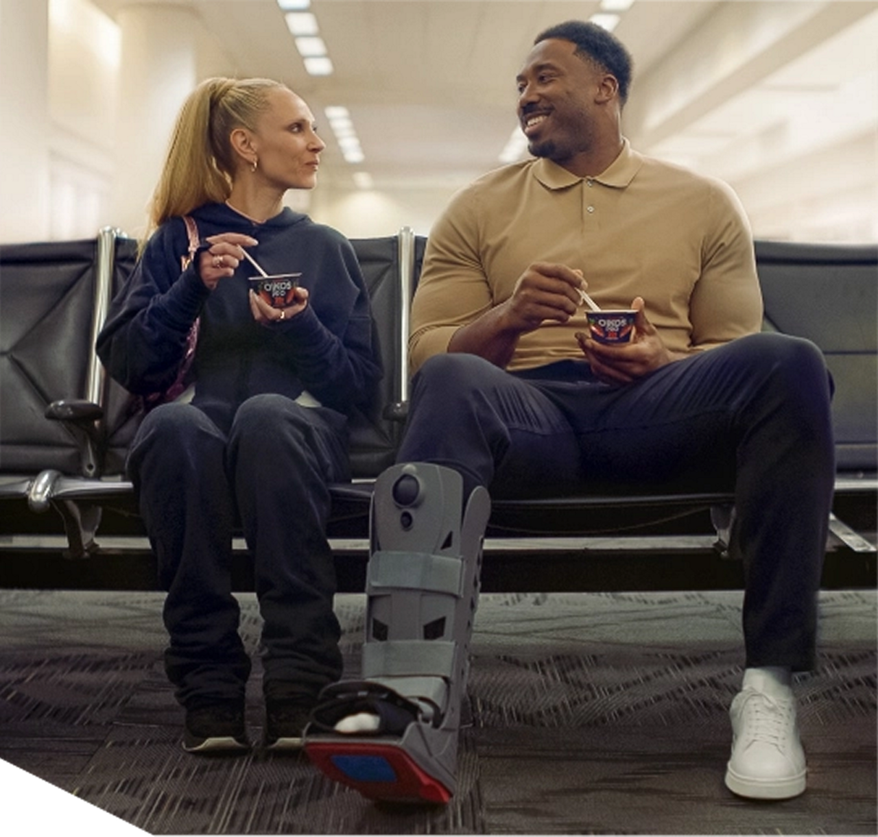 Two people eating yogurt at airport