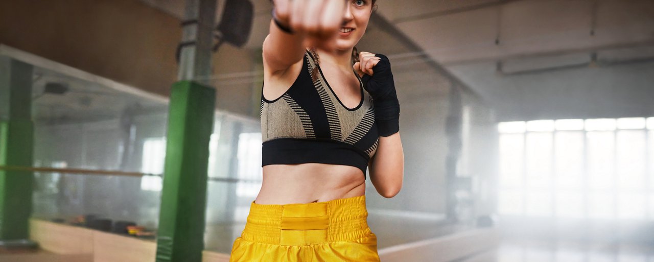 Junge Frau im Sportkleidung boxt