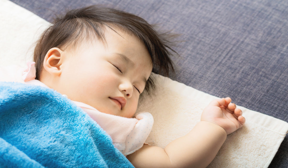 bé nằm ngủ trên giường