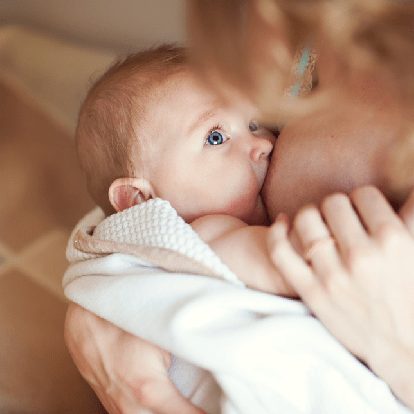 Bébé allaité lors d'un moment d'alimentation calme, favorisant une croissance saine, le développement et le lien d'attachement.