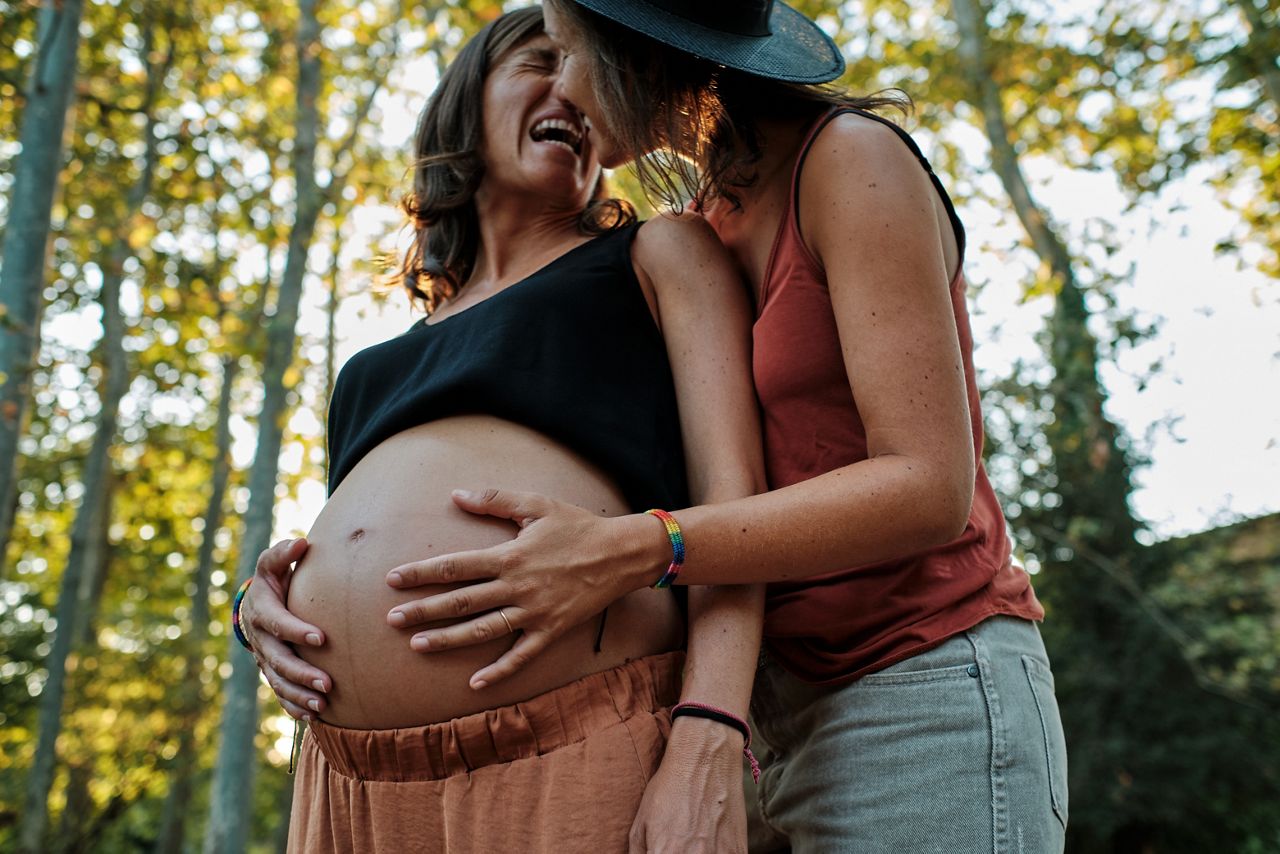 Lesbisches Paar hält Babybauch