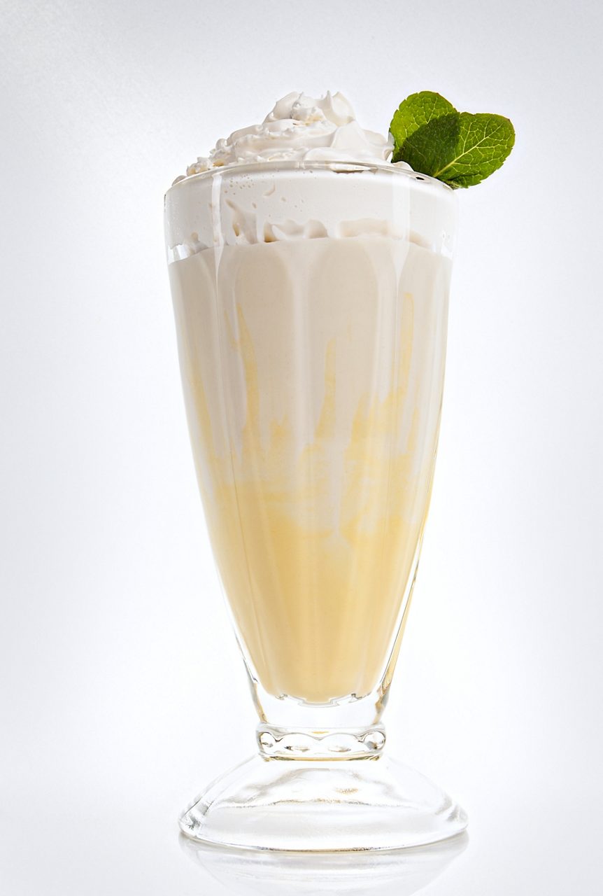 Banana milkshake in a tall glass with fresh mint